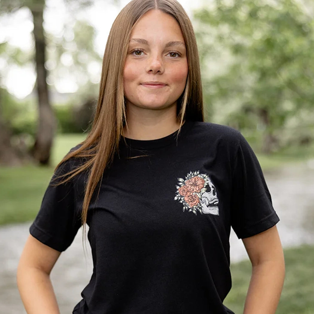 Black tshirt with light gray skeleton with flowers on front. Back of tee has gray skeleton with pink flowers in the middle and the words Be Fearlessly Authentic around it.