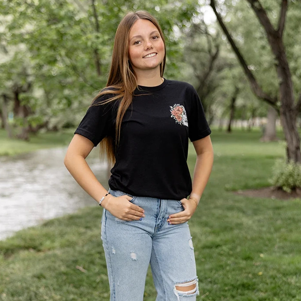 Black tshirt with light gray skeleton with flowers on front. Back of tee has gray skeleton with pink flowers in the middle and the words Be Fearlessly Authentic around it.