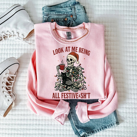 Pink crewneck with skeleton holding coffee with Santa hat wearing christmas lights. 