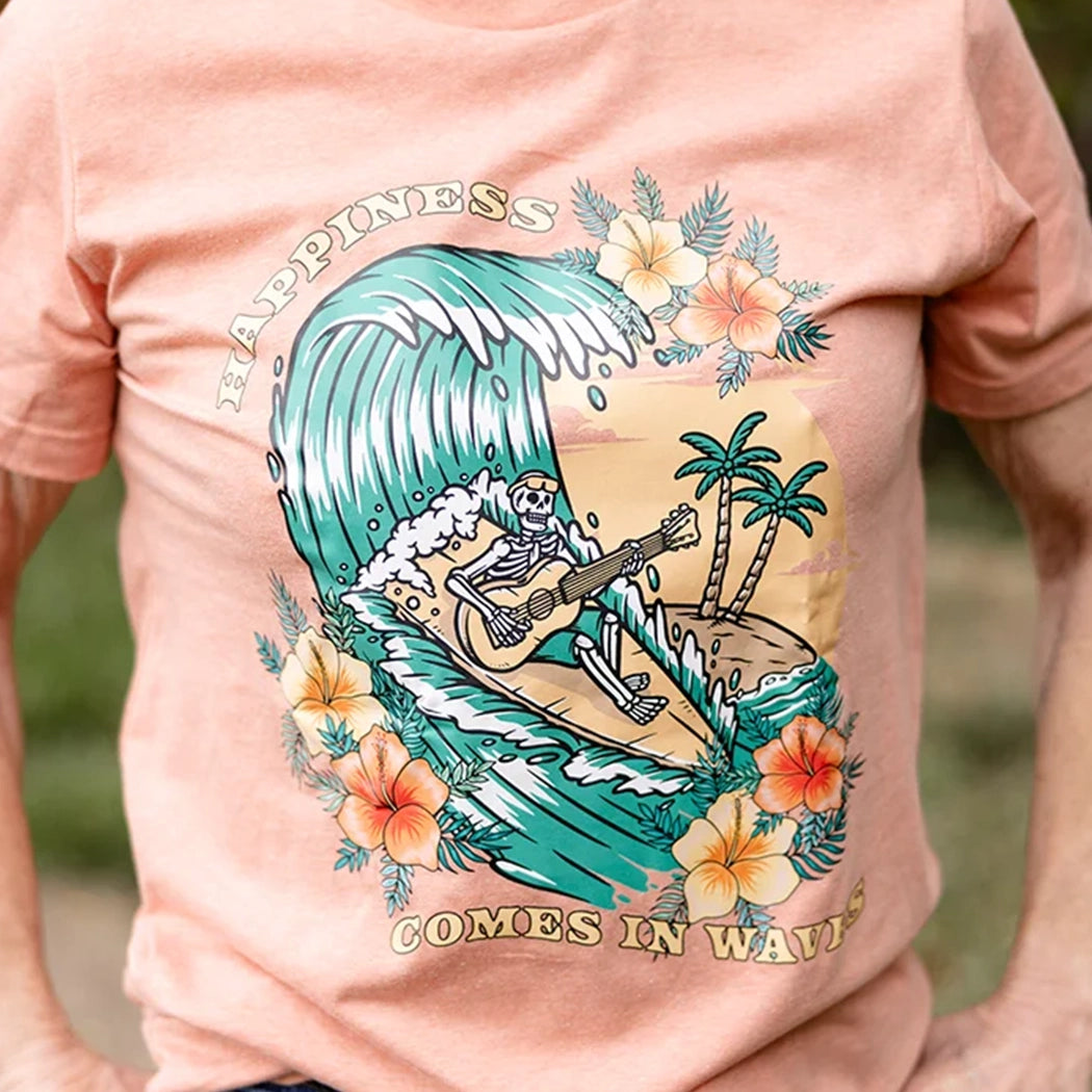 Happiness comes in waves design on a heather sunset t-shirt. Skeleton on surfboard playing guitar on wave with flowers and sunset. Yellow, orange and teal design. 