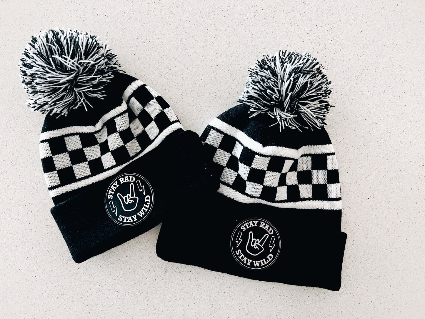 Black and white with checkered beanie. Patch that has rocker fingers and lightning bulb that says stay rad and wild.