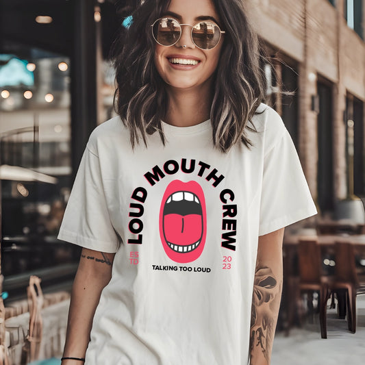 Introducing "Loud Mouth Crew" graphic tee – a must-have for those who love to make a statement with their style. This eye-catching t-shirt features the bold phrase "Loud Mouth Crew" prominently displayed in vibrant typography, showcasing your energetic personality. Crafted from soft, breathable cotton, this tee offers all-day comfort, making it perfect for casual outings, work from home days, or relaxed hangouts with friends.