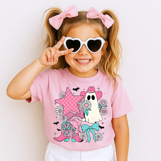 Child wearing a pink t-shirt with a ghost and star design, making a peace sign.