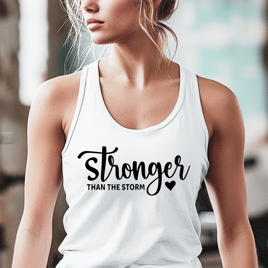 The workout tank has the text "Stronger Than The Storm" printed on it. The text is in a large, bold font and is centered on the tank. The tank is a light gray color and appears to be made of a soft, breathable fabric. It has a racerback style, which is designed to provide a full range of motion for the wearer. The tank is also moisture-wicking, which helps to keep the wearer cool and dry during exercise.