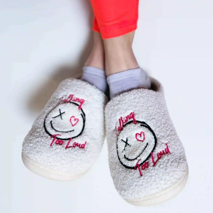 White slippers with Talking Too Loud logo.