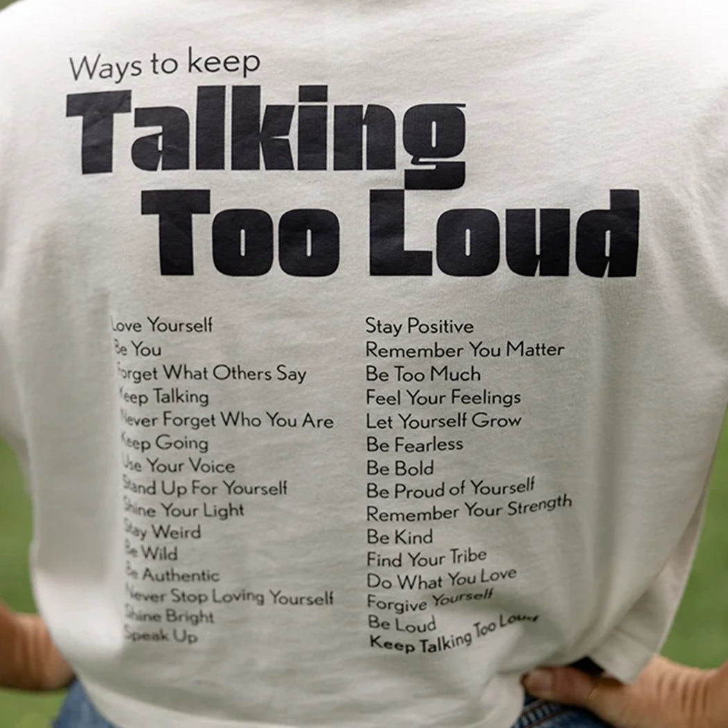 Woman wearing  vintage white crop top with saying "Ways to keep Talking Too Loud"