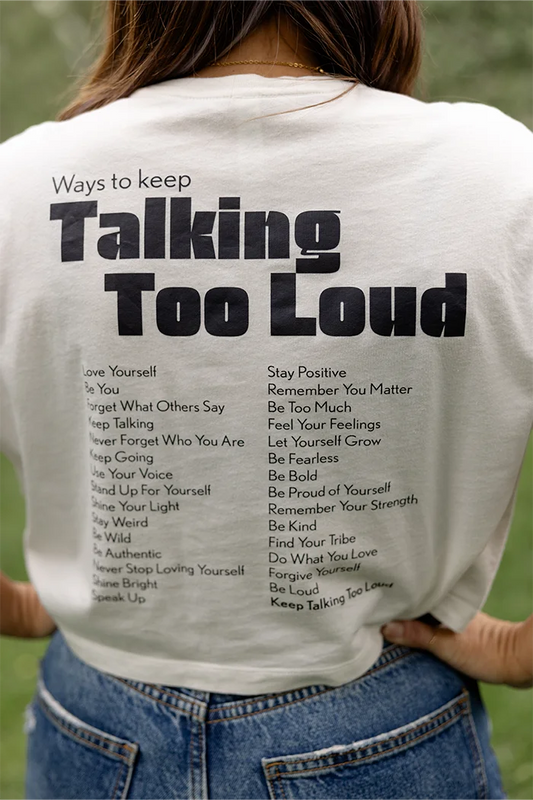 Woman wearing  vintage white crop top with saying "Ways to keep Talking Too Loud"
