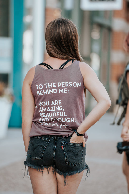 You matter graphic apparel tank top. Purple tank with white text that says to the person behind me: you are amazing, beautiful and enough. Remember that. 

Spread positivity and self-love with our 'To the Person Behind Me' graphic tee. This inspiring message reminds you and those around you that they are amazing, beautiful, and enough. It's a comfortable and stylish way to encourage self-acceptance and inspire others.