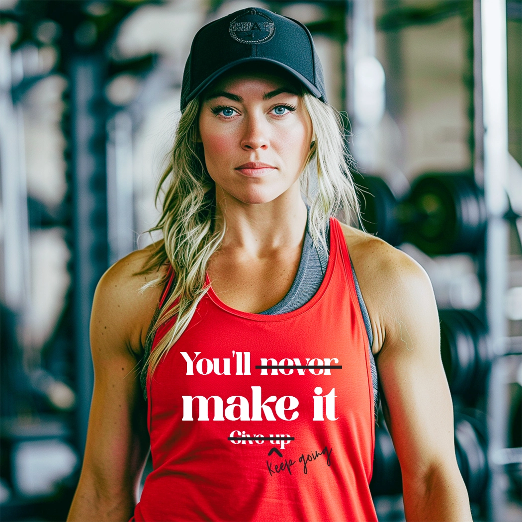 The workout graphic apparel tank has the text "You'll Make It. Keep Going. " printed on it. The text is in a large, bold font and is centered on the tank. The tank is a light gray color and appears to be made of a soft, breathable fabric. It has a racerback style, which is designed to provide a full range of motion for the wearer. The tank is also moisture-wicking, which helps to keep the wearer cool and dry during exercise.